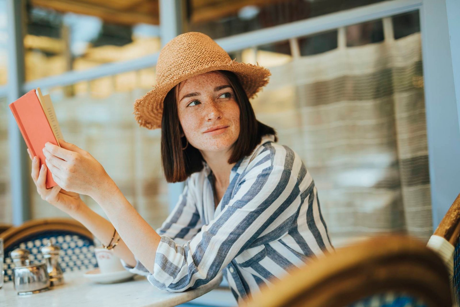 woman reading a book at a cafe
